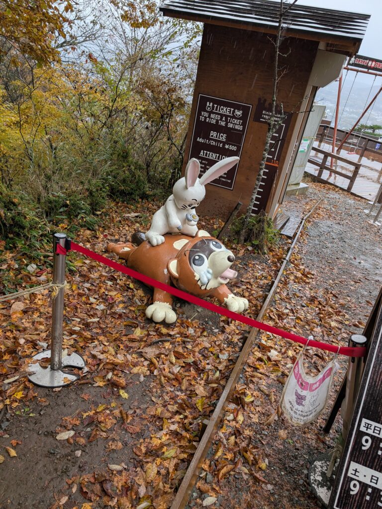 Bunny jumping on raccoon statue